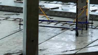 Yağmurda inşaat alanı. Temel, zemin, beton iskeleler ve gökdelen yığınları. Yüksek bina inşaatı. Şiddetli yağmur altında büyük bir binanın boş şantiyesi. Kötü hava
