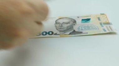 Paranın yeniden hesaplanması. Eller, beyaz arka planda Ukrayna Hrivnia senetlerini sayar. 500 Hrywna banknot paketi. Banknotlar yakın planda. UA para birimi. Para elinde. Yüksek kalite 4k görüntü