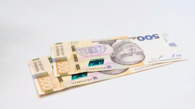 Recalculation of money. Hands count Ukrainian hryvnia bills on white background. Slow motion. Five hundred hrywna banknotes pack. Close-up. UA currency. Money in hand. High quality 4k footage