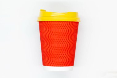 Paper coffee cup. Red craft paper coffee cup with yellow plastic lid. Disposable cup for safe drinking of hot and cold drinks. Safe ribbed capacity. Container for healthy beverage. Isolated. Close-up