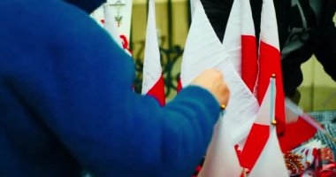 National Independence Day of Poland. Flag of Poland. The seller arranges Polish flags with the coat of arms and other souvenirs for sale. Celebration on the streets of Warsaw city