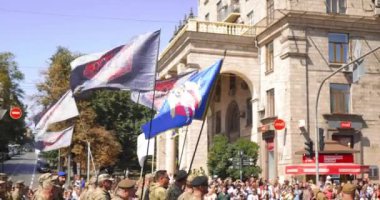 Ukrainian veterans march on the Maidan. Soldiers of the Armed Forces of Ukraine with blue-yellow and red-black battle flags march on the Maidan. Russian invasion. War in Ukraine
