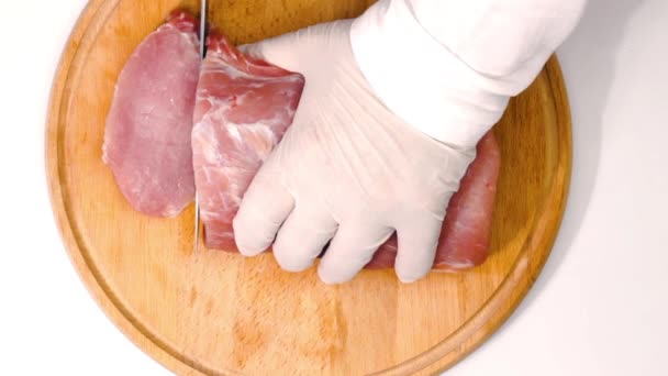 切一块肉 厨师用白色背景的木制切菜板上的一把大刀从一块多汁的肉上切牛排 健康的天然食品 肉是为烧烤准备的 后续行动 — 图库视频影像