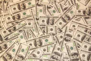 Masada bir sürü yüz dolarlık banknotlar var. Yüz dolarlık banknotlar. Amerikan doları. Banka ve finans tabelaları. Çok para geçmişi var. Üst Manzara. Yakın plan.