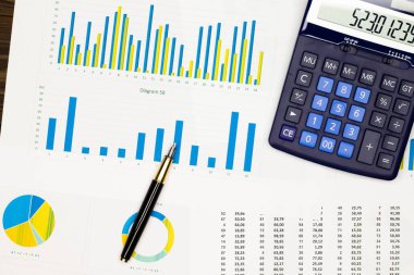 Üst kat ofis masası. Finansal rapor. Düz yatıyordu. İş yeri malzemeleriyle çalışma alanı, veri kağıdındaki hesap numarası, şemalar, kalem, hesap makinesi. Uzayı metin için kopyala. Üst görünüm