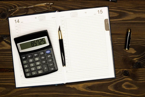 Top view office table desk. Financial report. Flat lay. Workspace with Business office supplies, empty sheet of diary, pen, glasses, calculator on the table. Copy space for text. Top view. Close-up