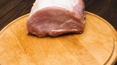 Aşçı ahşap kesme tahtasına bir parça et ve bıçak koyar. Tahta bir masada taze eti bifteğe dönüştürmeye hazırlanıyorlar. Barbekü, barbekü ve kebap. Mutfakta yemek pişirmek.