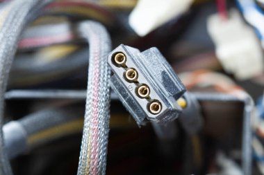 Çok kirli kablolar, konnektörler ve fişler bilgisayarda. Örgülü bir ambalajda eski renkli kablolar. Elektronik ekipmanlarda sıkışmış elektrik teli. Elektronik tamir için servis atölyesi.