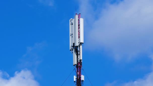 青い空と白い雲の背景にセルサイトアンテナ 電子通信機器を搭載したセルラータワー基地局 携帯電話通信機器付きのセルタワー テキストの場所 — ストック動画