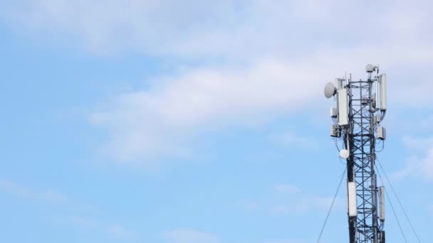 蓝天和白云背景上的蜂窝天线 带移动通讯设备的蜂窝塔 带有电子通讯设备的蜂窝塔基站 案文的位置 — 图库视频影像