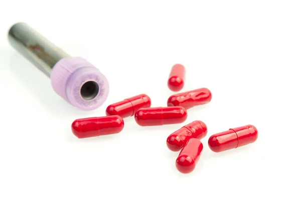 Reageerbuis in de buurt van rode pillen — Stockfoto