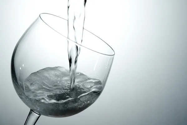 Pouring white wine into glass — Stock Photo, Image