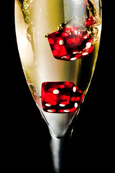 Red dice dropping in the champagne flute — Stock Photo, Image