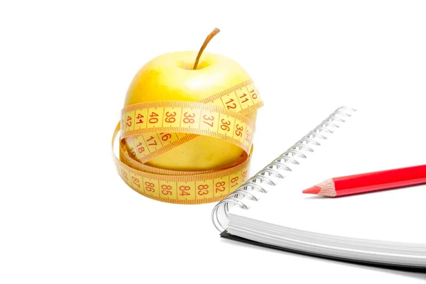 Una manzana con cinta métrica cerca del cuaderno — Foto de Stock