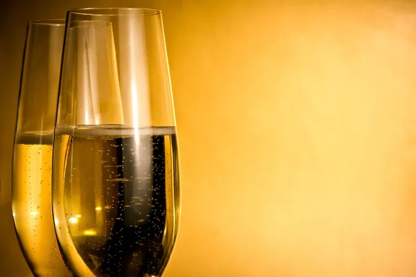 Dos copas de champán con burbujas doradas y espacio para texto — Foto de Stock