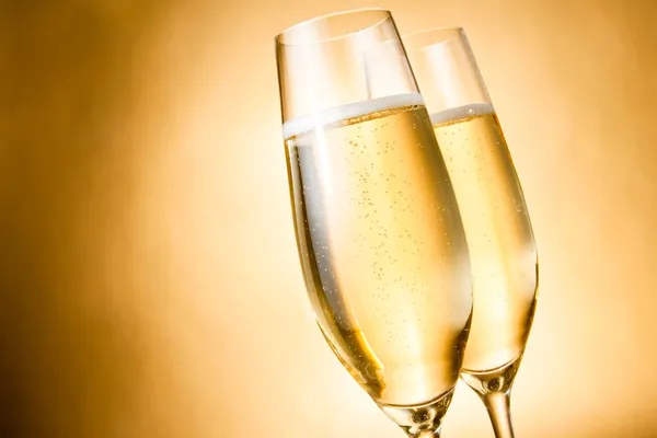 Due bicchieri di champagne con bollicine dorate e spazio per il testo Fotografia Stock