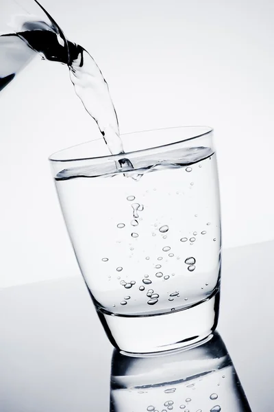 Filling a glass with pure water and bubbles — Stock Photo, Image