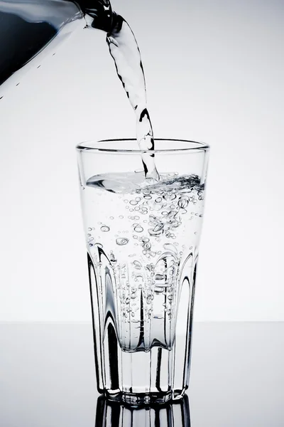 Наполнение стакана водой, показывающей концепцию напитка — стоковое фото