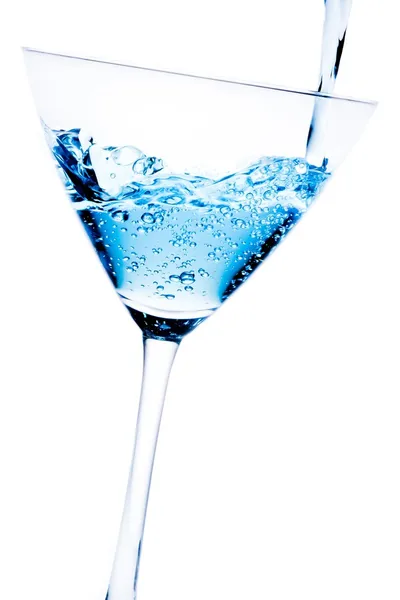 Filling a glass with blue cocktail tilted and bubbles — Stock Photo, Image