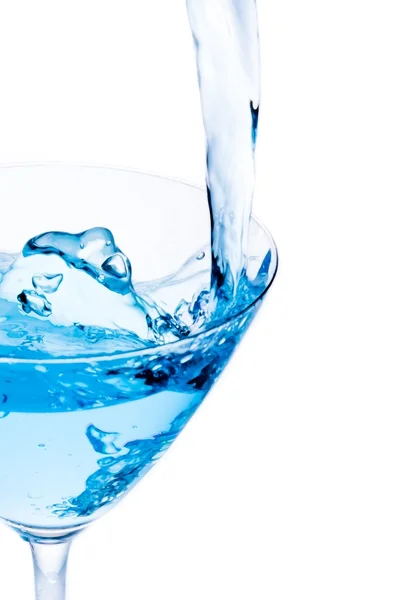 Filling a glass with blue cocktail with splash and space for text — Stock Photo, Image