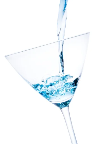 Pouring a glass with blue cocktail tilted and bubbles — Stock Photo, Image