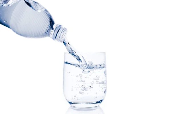 Pouring a glass with water trough little bottle and space for text — Stock Photo, Image