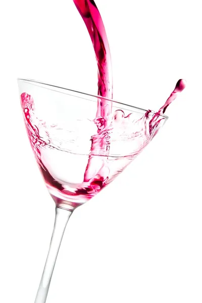 Filling a glass with red cocktail tilted and splashing — Stock Photo, Image
