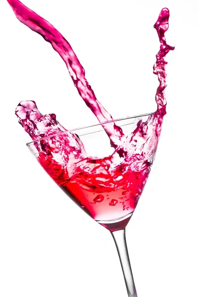 Red cocktail with splashing in the tilted glass — Stock Photo, Image