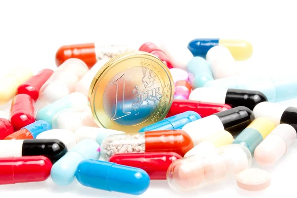 Евро монеты в центре медицинских таблеток — стоковое фото