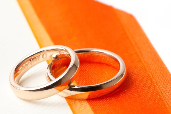 Gold wedding rings near orange ribbon — Stock Photo, Image