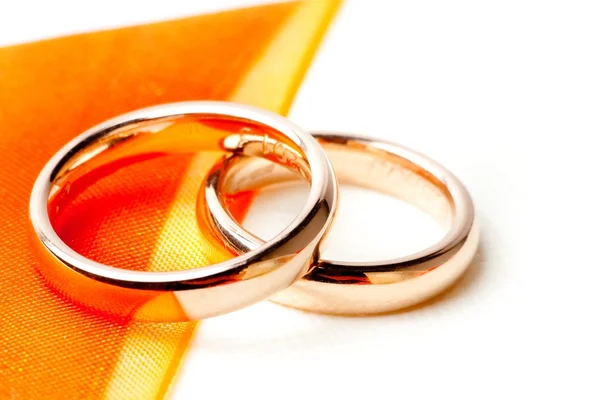 Gold wedding rings near orange ribbon — Stock Photo, Image