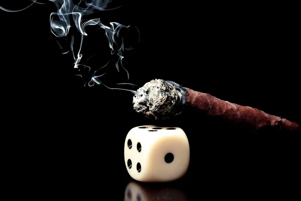 One white dice and cigar with smoke on black background — Stock Photo, Image