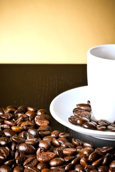 White cup with coffee near coffee beans — Stock Photo, Image