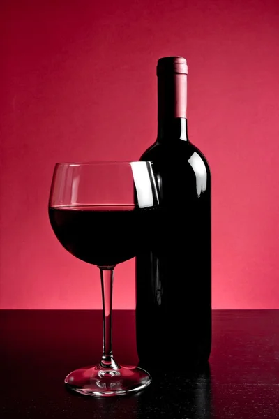 Red wine glass near bottle — Stock Photo, Image