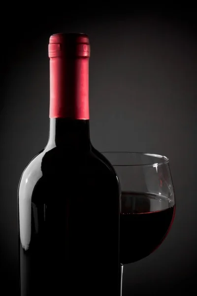 Rotweinglas in der Nähe der Flasche — Stockfoto