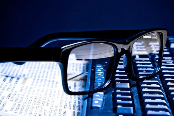 Glasögon på finansiell tidning — Stockfoto