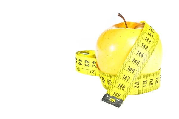Измерительная лента вокруг желтого яблока — стоковое фото
