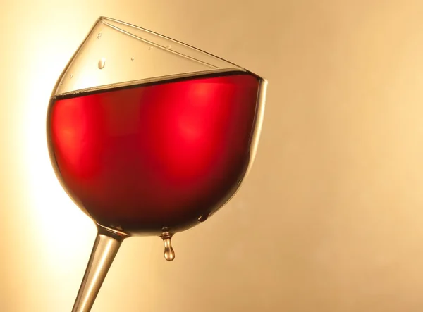Red wine in the glass tilted with golden drop and space for text — Stock Photo, Image