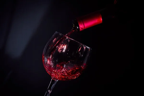 Sklenice na červené víno plné poblíž stín okna — Stock fotografie