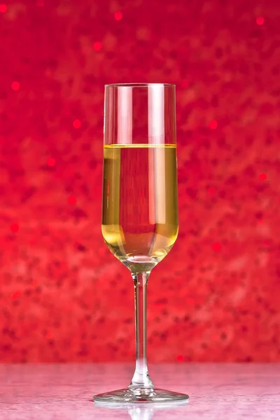 One flute of golden champagne abstract red background — Stock Photo, Image
