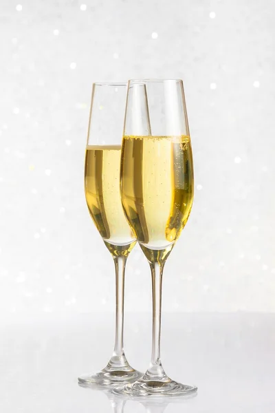 Un paio di flauti di champagne dorato su argento bokeh — Foto Stock
