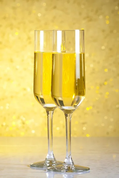 Ein Paar Flöten aus Champagner auf goldenem abstrakten Hintergrund — Stockfoto