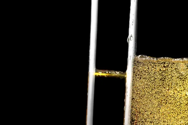 Detail of a pair of flutes of champagne with golden bubbles — Stock Photo, Image