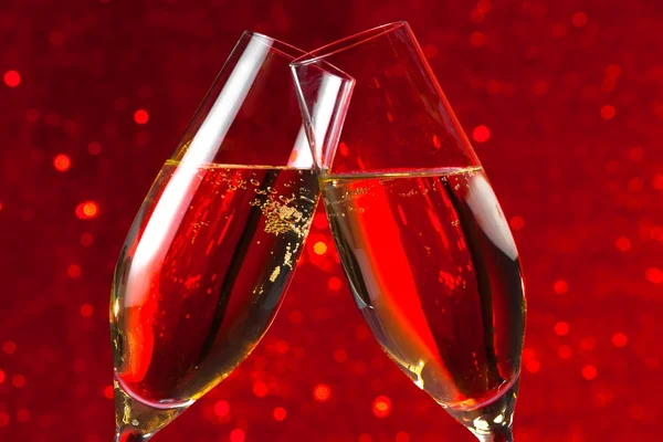 Dettaglio di due flauti champagne su sfondo bokeh luce rossa — Foto Stock