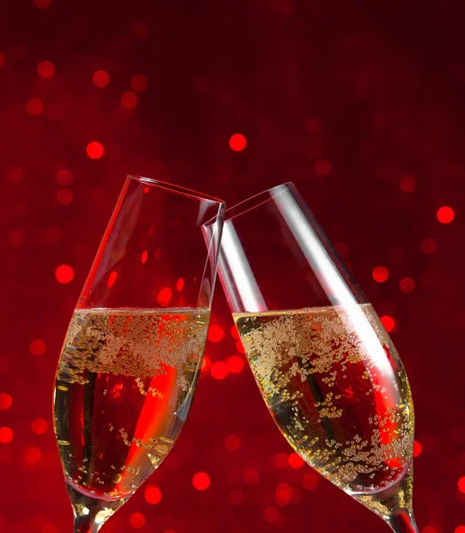 2 champagne fluiten op rood licht bokeh achtergrond — Stockfoto