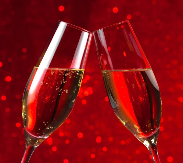 Pair of a champagne flutes on red light bokeh background — Stock Photo, Image