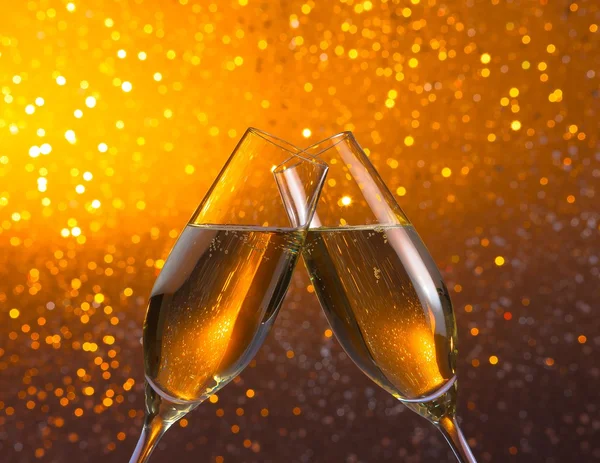 Champagne flutes on golden light bokeh background — Stock Photo, Image