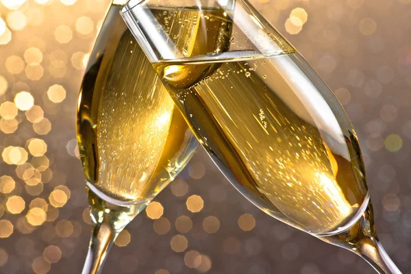 Detail van een champagne fluiten met gouden bubbels op lichte bokeh achtergrond — Stockfoto