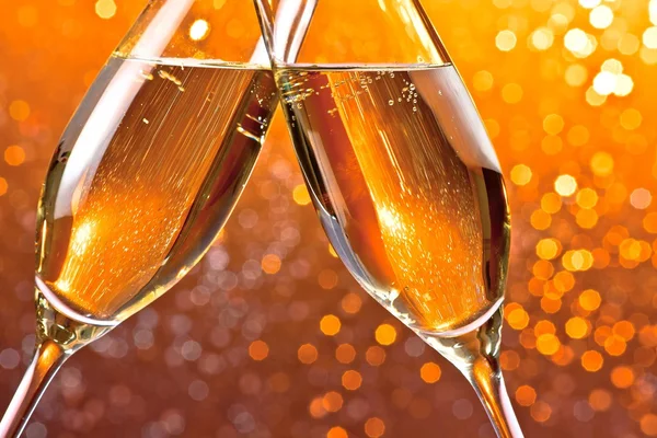 Detail šampaňské flétny na oranžové světlo bokeh pozadí — Stock fotografie