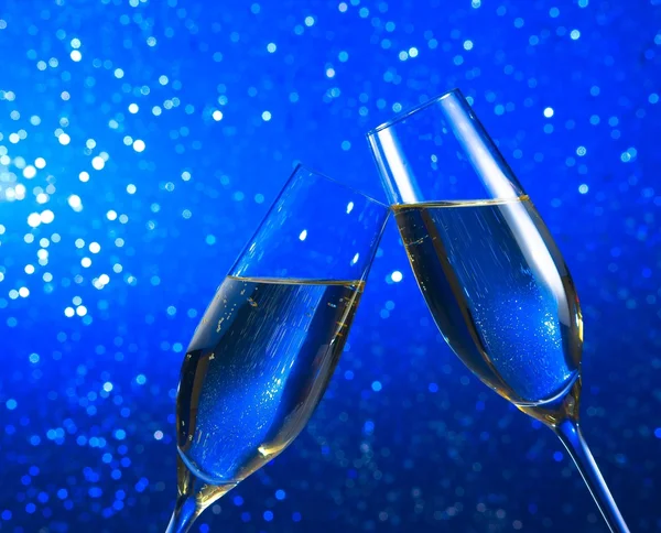 Champagne flöjter på blå ljus bokeh bakgrund — Stockfoto